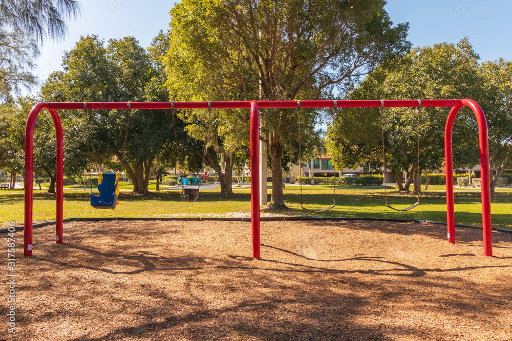 Playground for kids in sunny Florida. South west FL tropical landscape with children’s colorful equipment at a safe park. Bright and cheerful outdoors landscape.