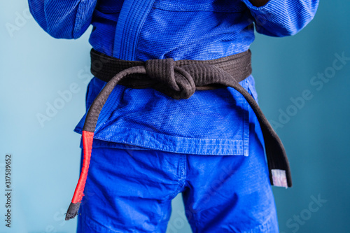 Photos Close up on midsection of the bjj brazilian jiu jitsu black belt tied around the