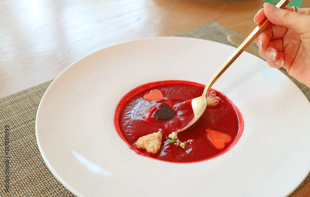 Female's Hand Scooping Beetroot Soup with Heart Shaped Vegetables in White Plate Female's Hand Scooping Beetroot Soup with Heart Shaped Vegetables in White Plate