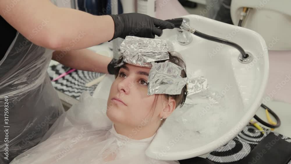 Professional hairdresser woman washes hair dye girl. Professional hairdresser woman washes hair dye girl.