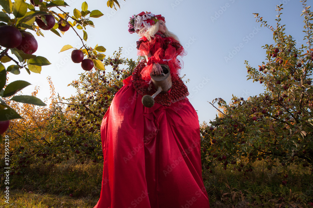 Sensual blond girl in fantasy red fairy tale stylization in apple park. Sensual blond girl in fantasy red fairy tale stylization in apple park.
