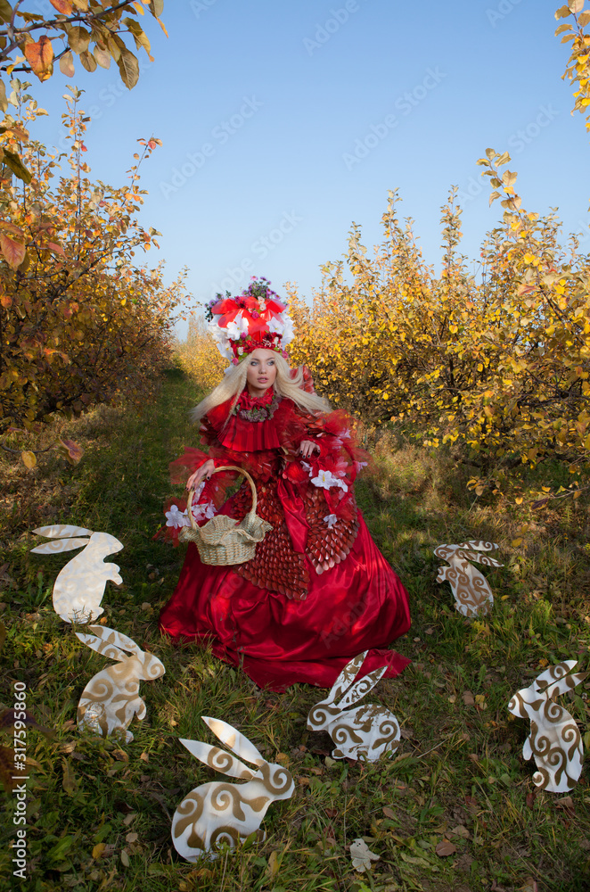 Sensual blond girl in fantasy red fairy tale stylization in apple park. Sensual blond girl in fantasy red fairy tale stylization in apple park.