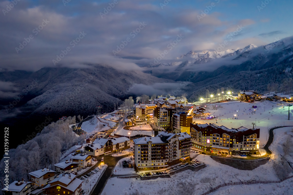 Night aerial view of the Ski Resort Rosa Khutor. A complex of hotels on the site of the former Olympic village of Rosa Plateau at an altitude of 1170 m from sea level. Krasnaya Polyana, Sochi, Russia