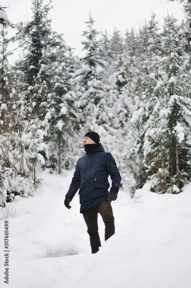 Traveler Man  in winter snowy forest landscape Travel Lifestyle concept adventure active vacations outdoor cold weather into the wild