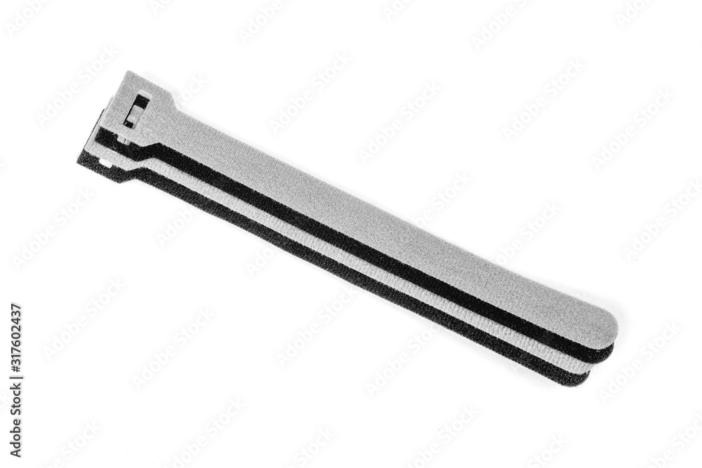 Black and grey Velcro Strips isolated on white background.Devices for storing cables, chargers Gadget tidy