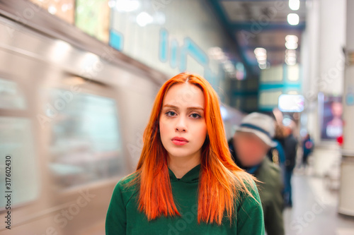 Sad redhead young woman looking to camera, describe alieniation and hardness of the city life