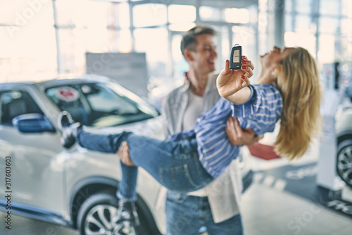 Happy couple having fun after buying a new car.