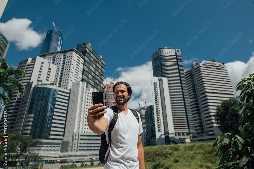 A man takes a selfie against the backdrop of skyscrapers A man takes a selfie against the backdrop of skyscrapers
