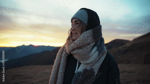 Close up view of stylish caucasian toung woman walks looks around enjoy the breathtaking view on mountain top trip travel nature outdoor sunrise tourist adventure landscape journay slow motion photo