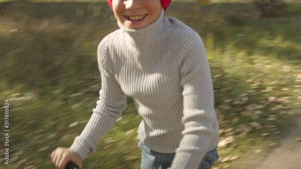Boy riding a scooter in the autumn forest. Boy riding a scooter in the autumn forest.