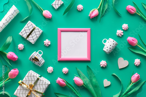 Geometric Valentine flat lay with Valentine's date February 14 on calendar, flowers, gifts, hearts, pink sweets, gifts and coffee cups. Valentines day decorations in white, pink and green, text space.