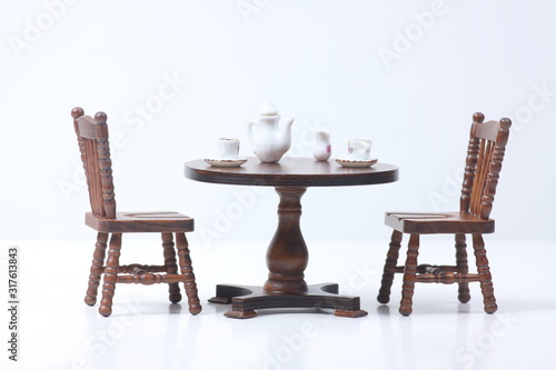 doll house interior - two chairs and a table served for tea isolated on white background