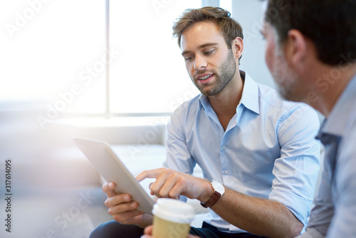 Young businessman presenting ideas with digital tablet