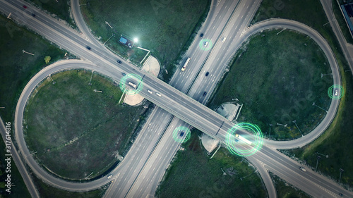 GPS navigation and autonomous driverless transportation concept. Aerial view of transport junction with cars and trucks driving with digital green circles, future global technology on roads. photo