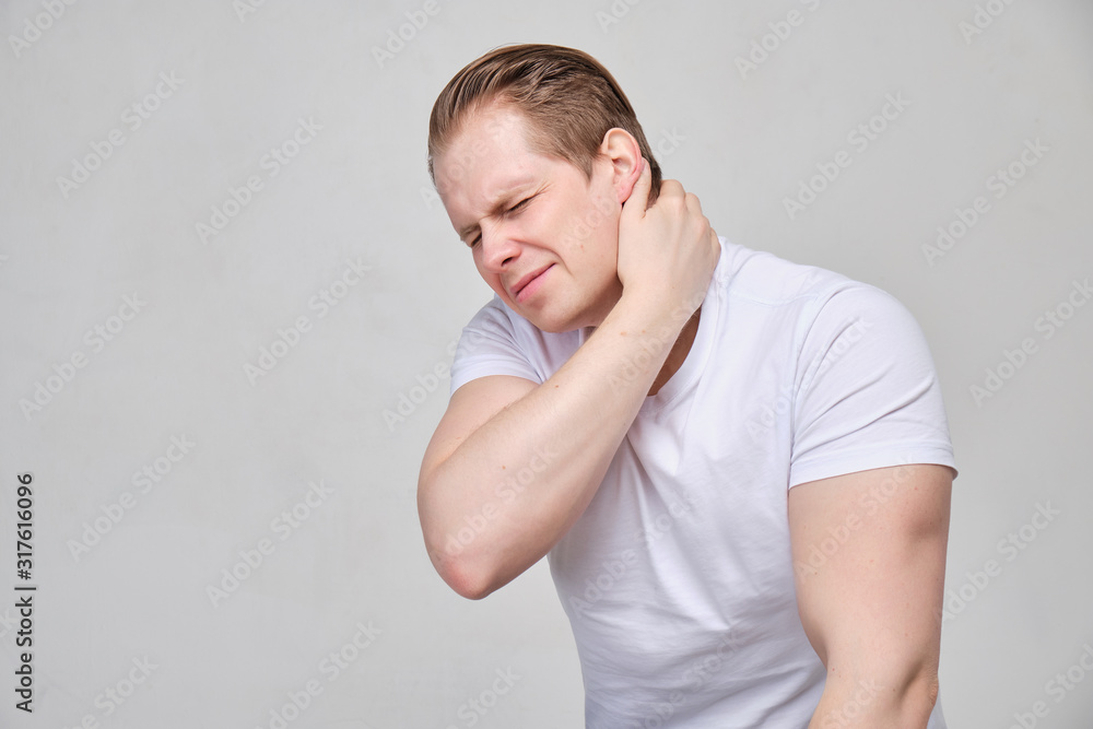 A man holds his neck with his hand. The concept of pain, ostechnodrosis. A man holds his neck with his hand. The concept of pain, ostechnodrosis.