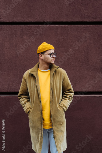 Photo of a young fashion stylish trendy look man model  in color clothes modern style outdoor street style  natural light