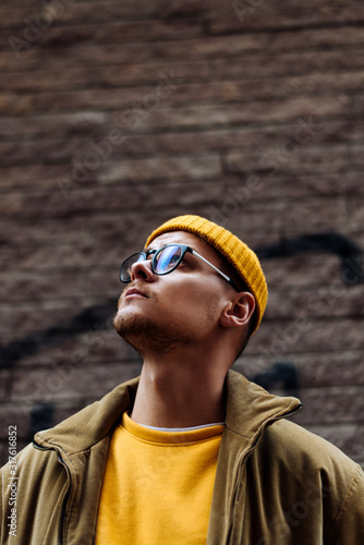 Photo of a young fashion stylish trendy look man model  in color clothes modern style outdoor street style  natural light