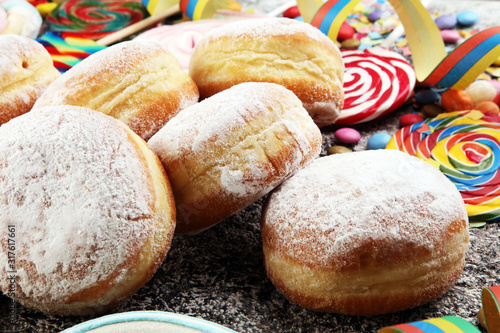 Carnival powdered sugar raised donuts with paper streamers. German berliner or krapfen for carnival photo