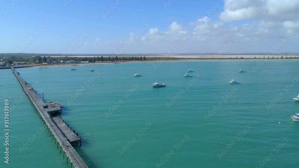 Aerial pan across Beachport Jetty and vivid turquoise ocean water in South Australia Aerial pan across Beachport Jetty and vivid turquoise ocean water in South Australia