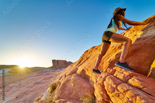 High angle view of female african american hiker climbing rock at Valley of Fire in nevada desert