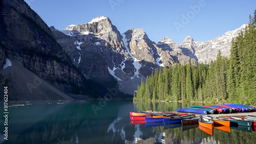 a morning shot of canoes tied up to a dock at moraine lake in banff national park