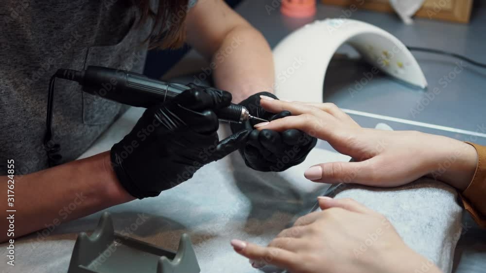 Beautician Salon, Manicure, Nails Polish Procedure. Professional hardware manicure using electric machine in beauty salon. master uses an electric machine to remove nail polish hands during manicure