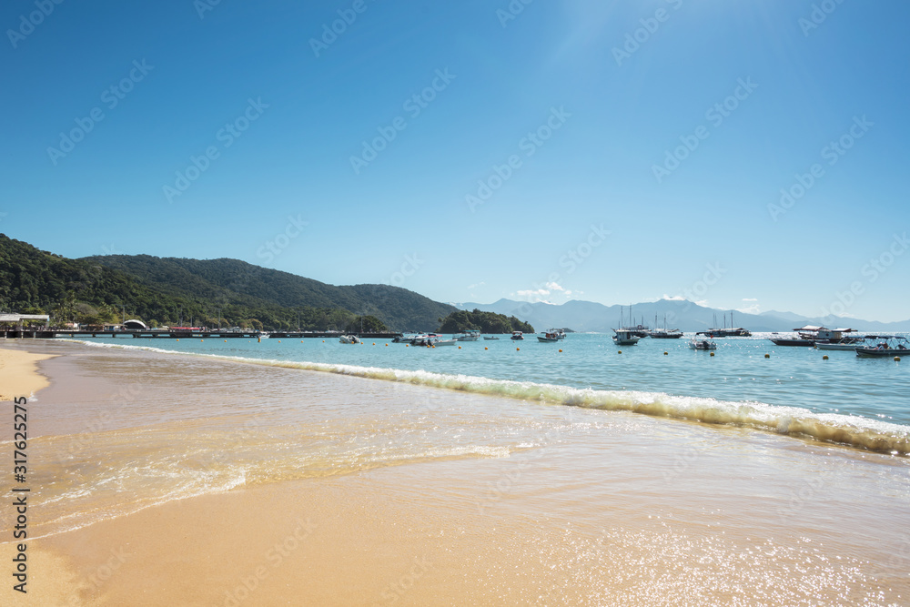 Abraaozinho beach with taxi boat and blue waters in Abraao, on the tropical Ilha Grande, Angra dos Reis, in the south of Rio de Janeiro Brazil
