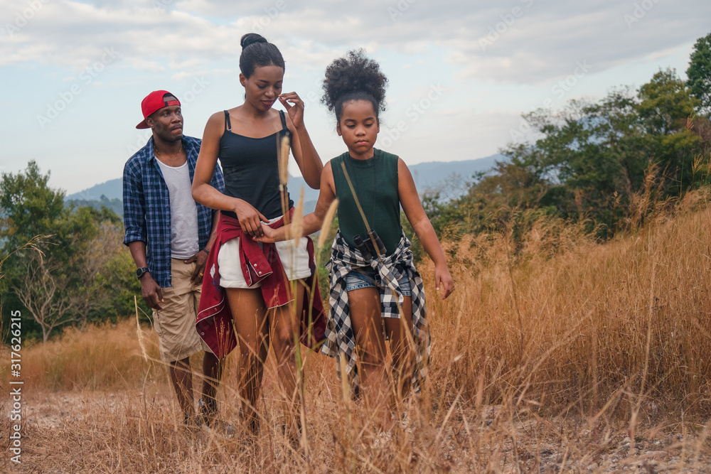 african american family having fun traveling and camping together in natural forest and park