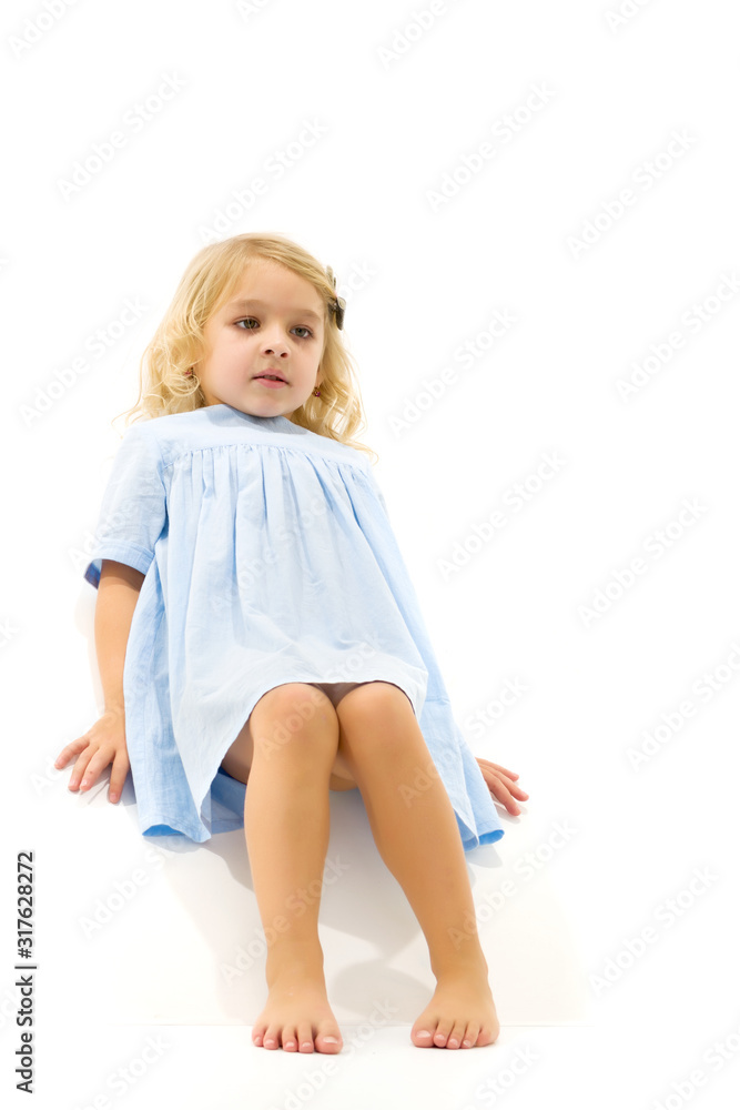 Little girl lies on the floor.Studio photo shoot on a white back Little girl lies on the floor.Studio photo shoot on a white back