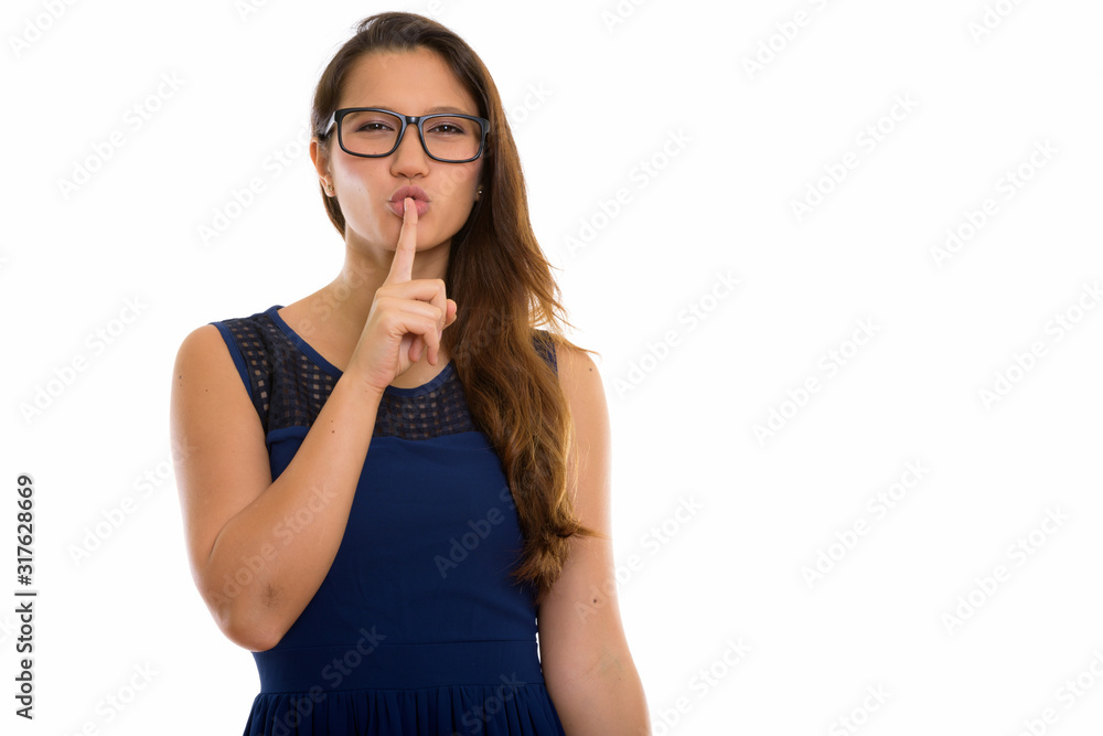 Studio shot of young beautiful woman with finger on lips