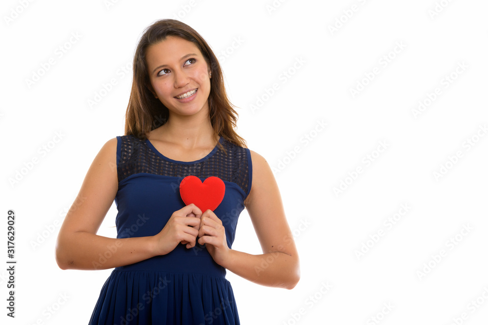Portrait of happy young beautiful woman holding heart while thinking Portrait of happy young beautiful woman holding heart while thinking
