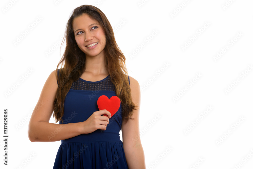 Portrait of happy young beautiful woman holding heart while thinking Portrait of happy young beautiful woman holding heart while thinking