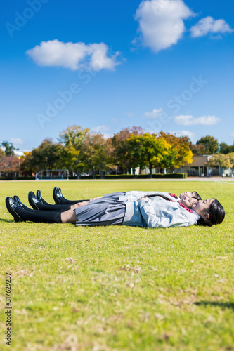 芝生に寝転ぶ高校生