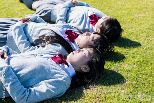 芝生に寝転ぶ高校生