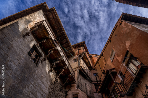 Narrow medieval alley way with passage made of terracotta red stone in Albarracin Spain