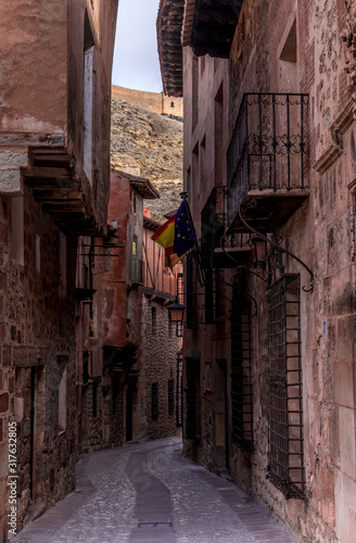 Narrow medieval alley way with passage made of terracotta red stone in Albarracin Spain © tamas