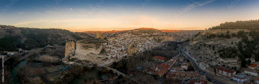 Sunset aerial panorama view of Alcala del Jucar medieval historic village with white washed houses and a castle on a rock in Albacete Spain