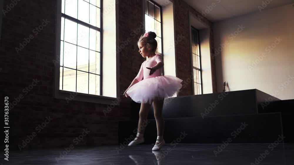 Child Little ballerina in pink tutu dancer. Children's ballet. Slow motion
