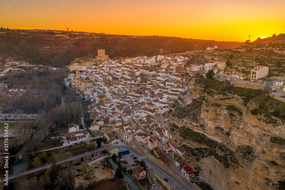 Sunset aerial panorama view of Alcala del Jucar medieval historic village with white washed houses and a castle on a rock in Albacete  Spain