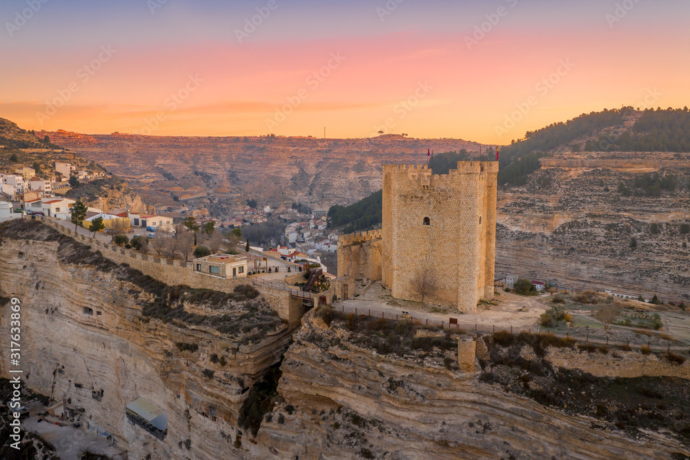 Sunset aerial panorama view of Alcala del Jucar medieval historic village with white washed houses and a castle on a rock in Albacete Spain Sunset aerial panorama view of Alcala del Jucar medieval historic village with white washed houses and a castle on a rock in Albacete Spain
