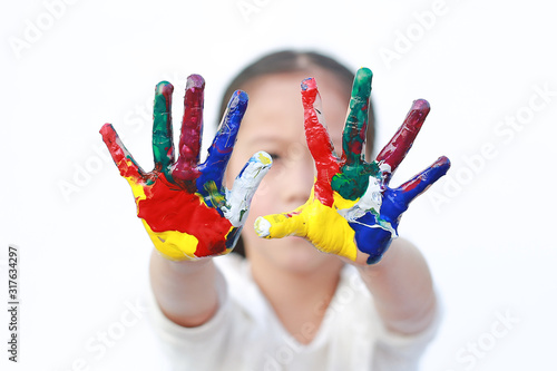 Little girl with colorful hands painted isolated on white background. Focus at child hands.
