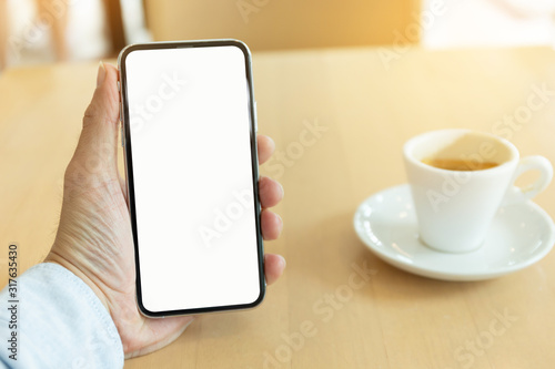 Wallpaper Mural Mockup image blank white screen cell phone.man hand holding texting using mobile on desk at coffee shop.background empty space for advertise text.people contact marketing business,technology  Torontodigital.ca