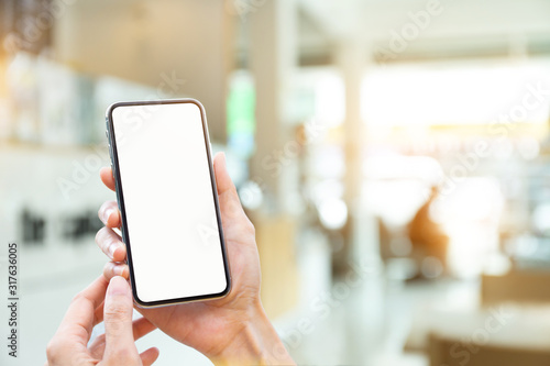 Mockup image blank white screen cell phone.man hand holding texting using mobile on desk at coffee shop.background empty space for advertise text.people contact marketing business,technology 