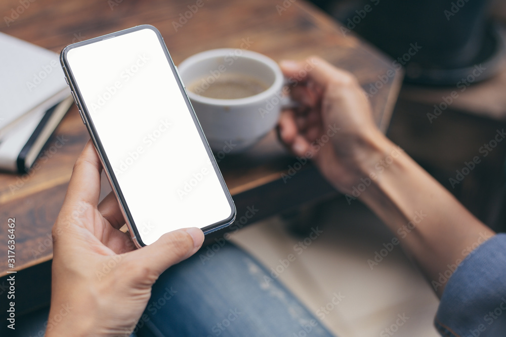 Mockup image blank white screen cell phone.man hand holding texting using mobile on desk at coffee shop.background empty space for advertise text.people contact marketing business,technology 