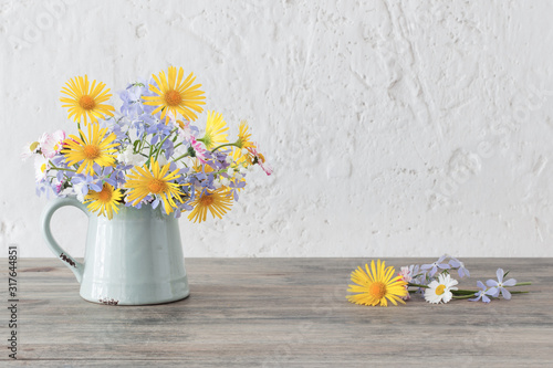 spring flowers in vintage jug on wooden table