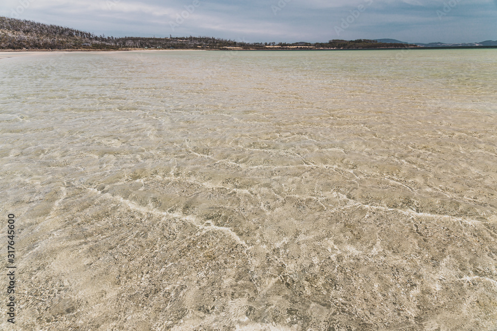 view of Dunalley Beach in Tasmania, Australia with sandbanks and shallow pristine water view of Dunalley Beach in Tasmania, Australia with sandbanks and shallow pristine water