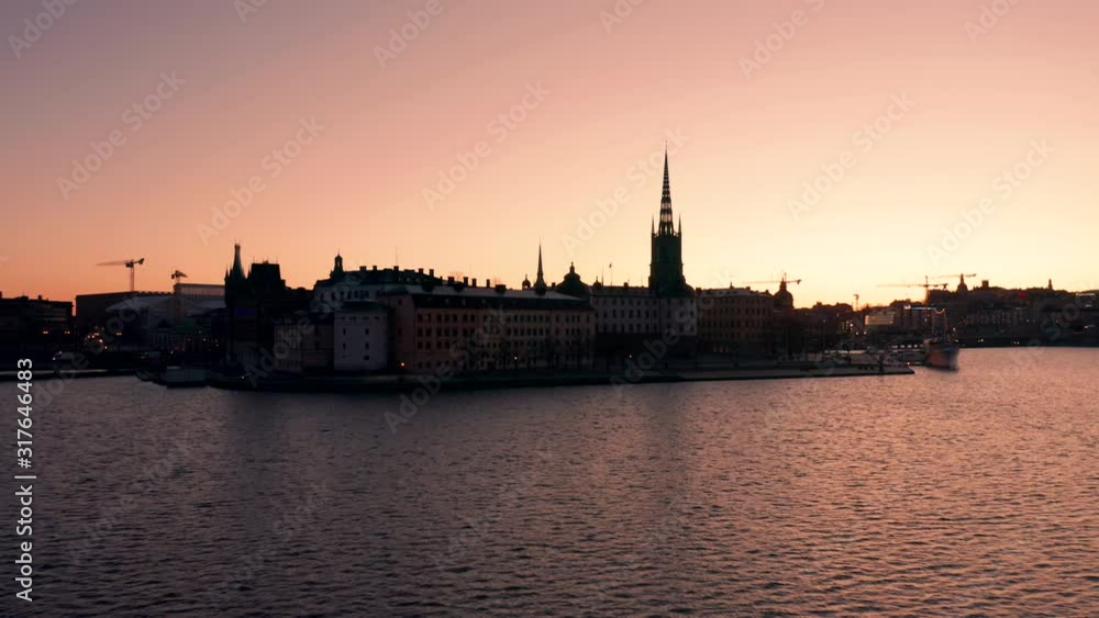 Sunrise silhouette view of Riddarholmen in Stockholm. Flying toward the sland Sunrise silhouette view of Riddarholmen in Stockholm. Flying toward the sland