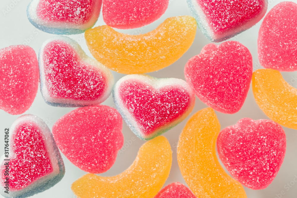 Pink and yellow chewy candies in powdered sugar, gelatin sweets close-up on a neutral background Pink and yellow chewy candies in powdered sugar, gelatin sweets close-up on a neutral background