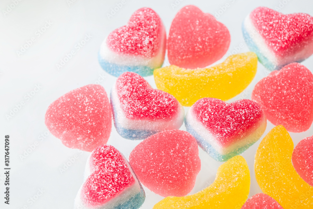 Pink and yellow chewy candies in powdered sugar, gelatin sweets close-up on a neutral background Pink and yellow chewy candies in powdered sugar, gelatin sweets close-up on a neutral background