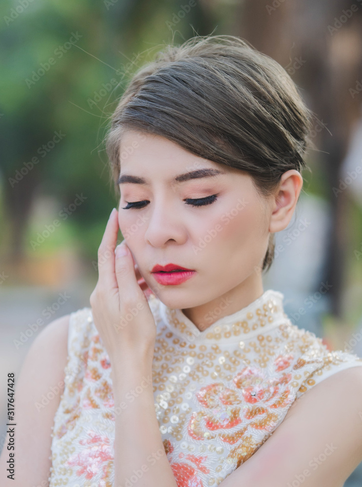 Close-up of Asian women wearing cream-colored Chinese outfits in close eyes. Close-up of Asian women wearing cream-colored Chinese outfits in close eyes.